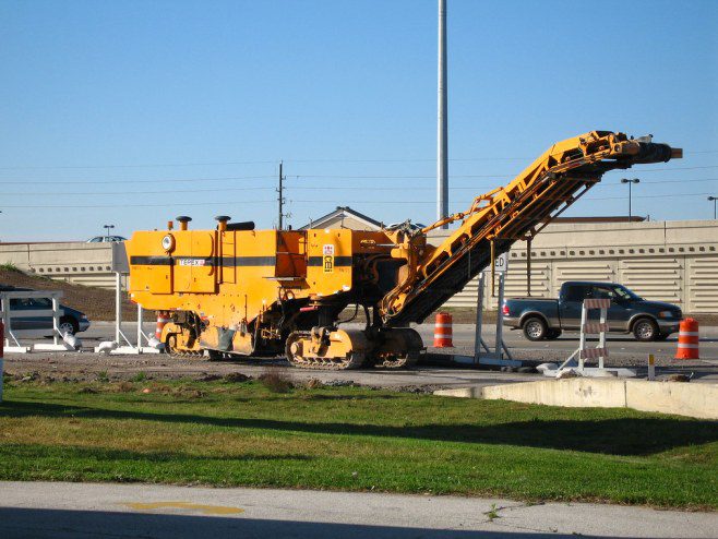 A large yellow machine is parked in the grass.